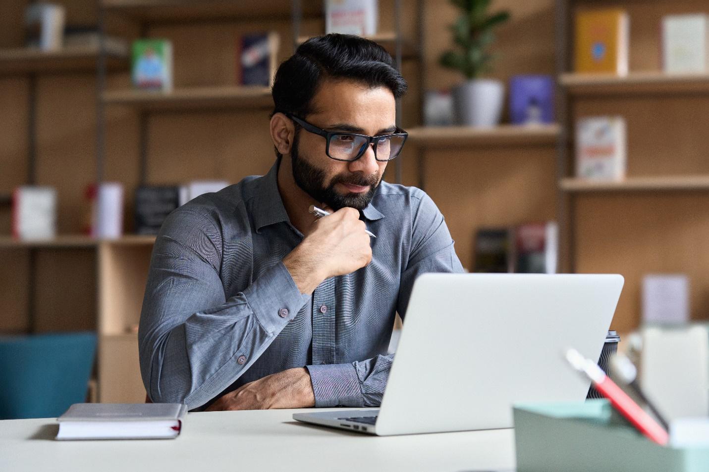 Blue-shirted IT professional seriously considering laptop and device security issues.